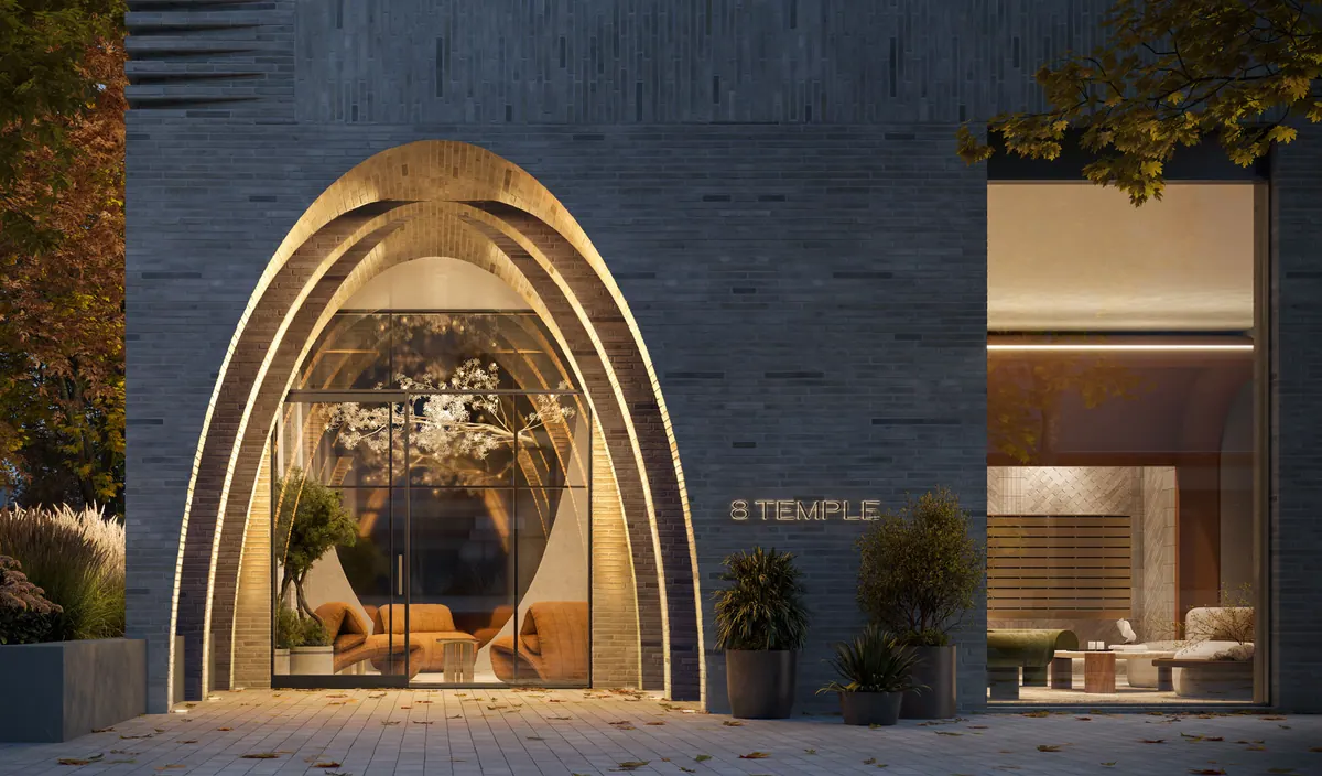 Artist's concept of 8 Temple's arched masonry entrance, glowing at dusk, with the lobby lounge visible through the glass